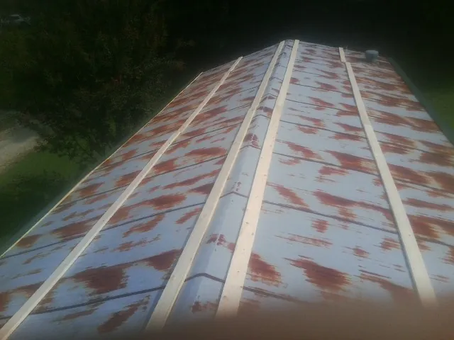 Rusted metal roof panels with new wood purlins before replacement — Storm Damage Roof Repair in Wauneta by Roofing Brothers