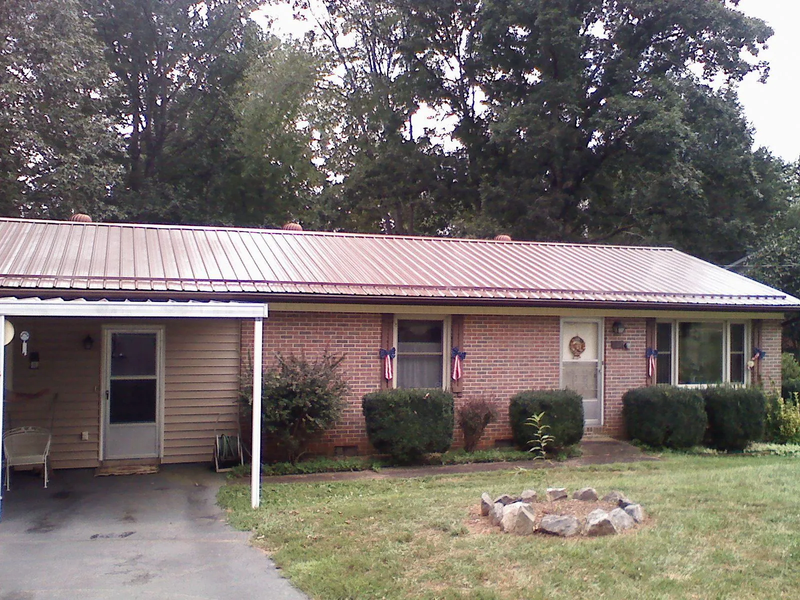 Bronze metal roof and carport on a brick ranch home — Roof Repair work by our crew in Wauneta
